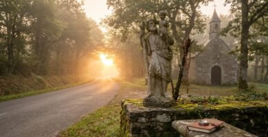 Obraz przedstawiający posąg św. Krzysztofa stojący przy drodze obsadzonej drzewami, w tle kościół
