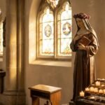 Statua św. Rity w pustym kościele obok stołu pełnego świec misyjnych